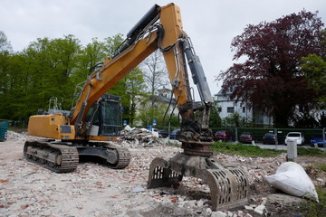 Fototapeta na wymiar Building rubble removal by an excavator on a construction site.