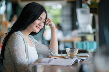 Portrait of smiling woman drinking coffee at vintage cafe