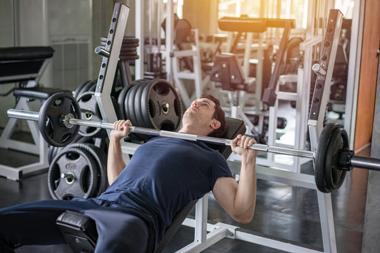 Handsome Weightlifter Lifting Barbells Bench Press Working Out With Curl Bar In The Gym