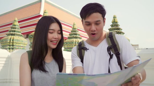 Traveler Asian couple direction on location map in Bangkok, Thailand, sweet Asia couple looking on map find landmark while spending holiday trip. Lifestyle couple travel in city concept.