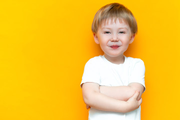 Portrait of smiling happy child 3 years old mixed race half Asian half Caucasian on yellow background with blonde hair and green eyes