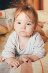 Fototapeta premium little girl with a tail on her head crawling on the floor