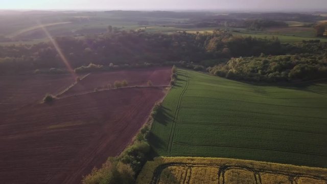 Aerial view of rolling hills in Poland. Colorful farming fields captured 
early spirng, during sunrise.