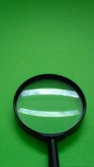 Magnifier glass on green background