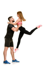 Fototapeta na wymiar Sporty couple having fun. muscular man carrying fit woman in arms