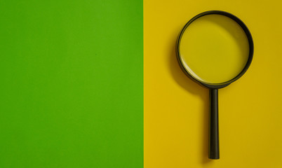 Magnifier glass on yellow and green background