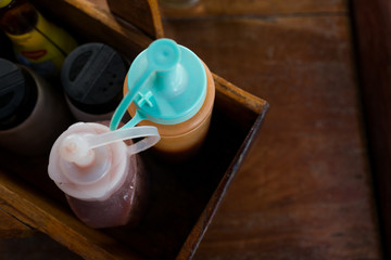 Bottles of Ketchup and Chili sauce in wooden container
