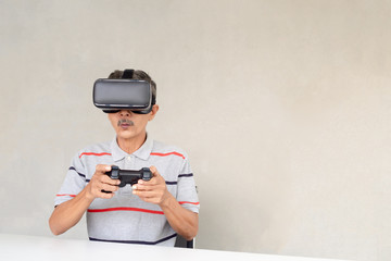 Asian Elderly men are enjoying modern technology...Play online games through virtual reality glasses..The lifestyle of modern people.
