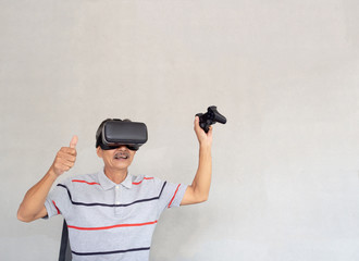 Asian Elderly men are enjoying modern technology...Play online games through virtual reality glasses..The lifestyle of modern people who use to communicate with others.