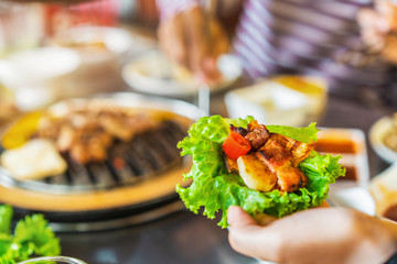 Korean BBQ bulgogi beef and lettuce held in hand, Selective focus.
