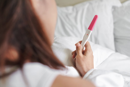 Unhappy young asian woman holding pregnancy test showing a negative result, Selective focus,wellness and healthy concept, infertility problem.