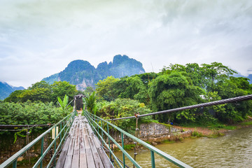 Fototapety  Wooden suspension bridge crossing the river Vang Vieng Laos