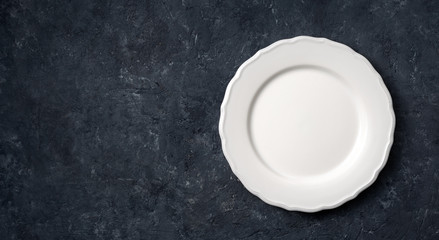 Obraz na płótnie Canvas White vintage ceramic empty plate on dark stone background