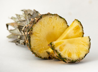 Delicious fragrant appetizing pineapple cut into slices for dessert with a light background