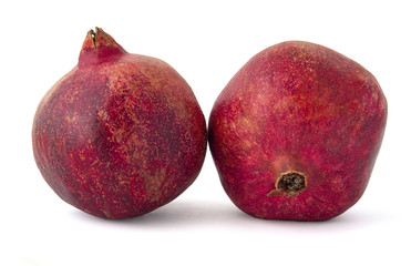 Ripe burnt and charged with sunlight a pair of pomegranate fruits on a white background