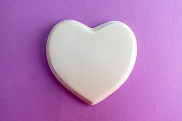  White glossy porcelain heart on a purple, lilac background; wedding; Wedding card; Love note. Copy space