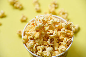 Popcorn in cup bowl and yellow backgroubd top view / Sweet butter popcorn salt