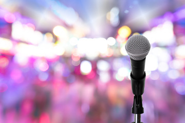 Microphone on stage ..Close up of dynamic microphone setting on stand with colorful light bokeh...
