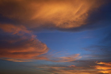 Beautiful vibrant orange cloud and blue sunset sky .