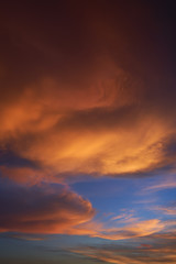 Naklejka na ściany i meble Beautiful vibrant orange cloud and blue sunset sky . Vertical format