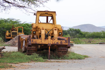 Yellow bulldozer abandoned, damaged and rusted