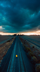 Person in Yellow Jacket on Old Train Tracks With Epic Sky - 266252295
