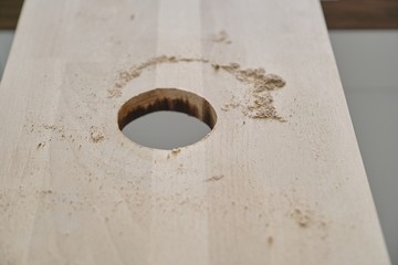 Closeup of making hole in wooden plank panel with woodworking electric tools, carpentry, woodwork, profession, people