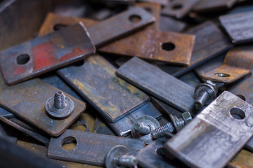 Close up of metal piece and nuts scattered on the table