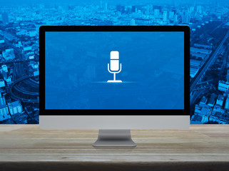 Microphone flat icon on desktop modern computer monitor screen on wooden table over city tower, street, expressway and skyscraper, Business communication online concept