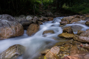 Naklejka na ściany i meble Rocks in stream with smooth flowing water