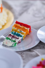 Colorful cake slice on white table.