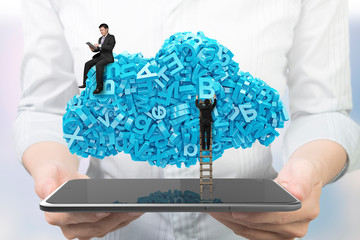 Big data and cloud computing concept. Woman hands holding digital tablet with businessmen teamwork on cloud of blue letters and numbers, front view.