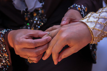 Muslim traditional way in Malaysia to welcome bride by her mother in law by giving a gold ring.