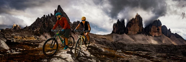 Fotobehang Fietsen vrouw en man rijden op fietsen in de bergen van de Dolomieten andscape. Paar fietsen MTB enduro trail track. Buitensport activiteit. © Gorilla