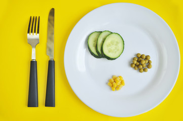 Conceptual image of diet theme. Plate with some food. The word diet made from peas.