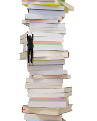 Climbing businessman hang on high stack of books, isolated on white background.