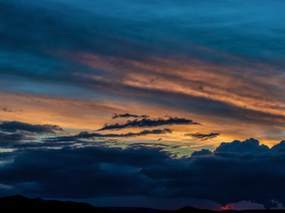 Springtime sunset with rain clouds and mountains in background