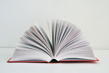 An open red book on a light background with an area for an inscription or text