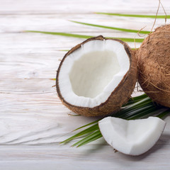 Coconut and shell pieces on white wooden table