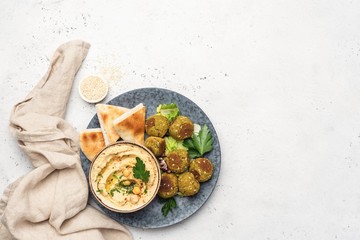 Hummus chickpea, falafel and pita bread. Arabic cuisine food, vegan appetizer. Top view on grey...