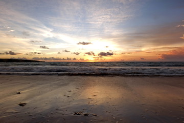 the beauty of Jimbaran beach in Bali Indonesia at dusk with the sun disappearing