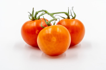 Three red tomatoes with branch