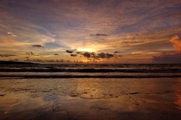 the beauty of Jimbaran beach in Bali Indonesia at dusk with the sun disappearing