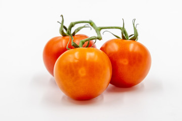 Three red tomatoes with branch