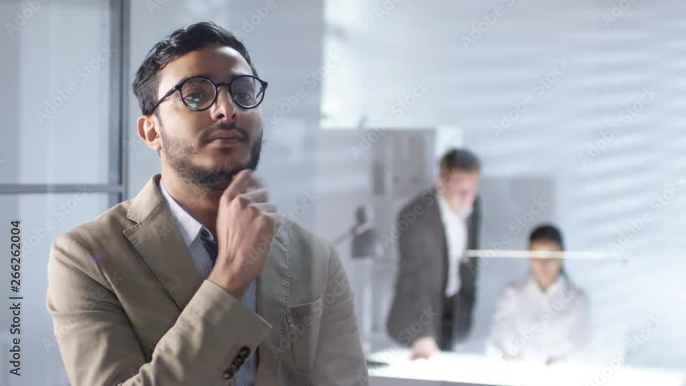 Poster handsome middle eastern businessman in eyeglasses swiping and tapping on invisible multi-touch scree
