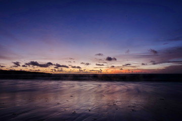 the beauty of Jimbaran beach in Bali Indonesia at dusk with the sun disappearing