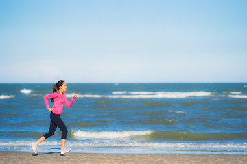Portrait beautiful young asian woman running or exercise on the tropica nature landscape of beach