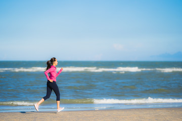 Portrait beautiful young asian woman running or exercise on the tropica nature landscape of beach