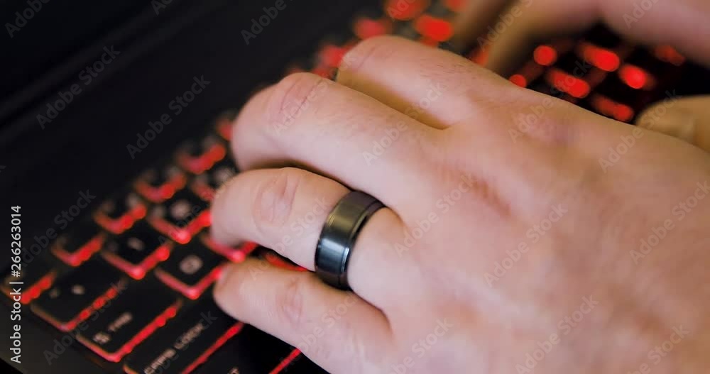 Poster man begins typing on a laptop computer - viewed from side