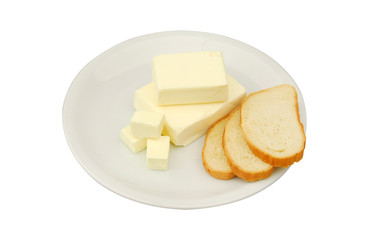 Butter and slices of bread are lying on a plate on a white isolated background